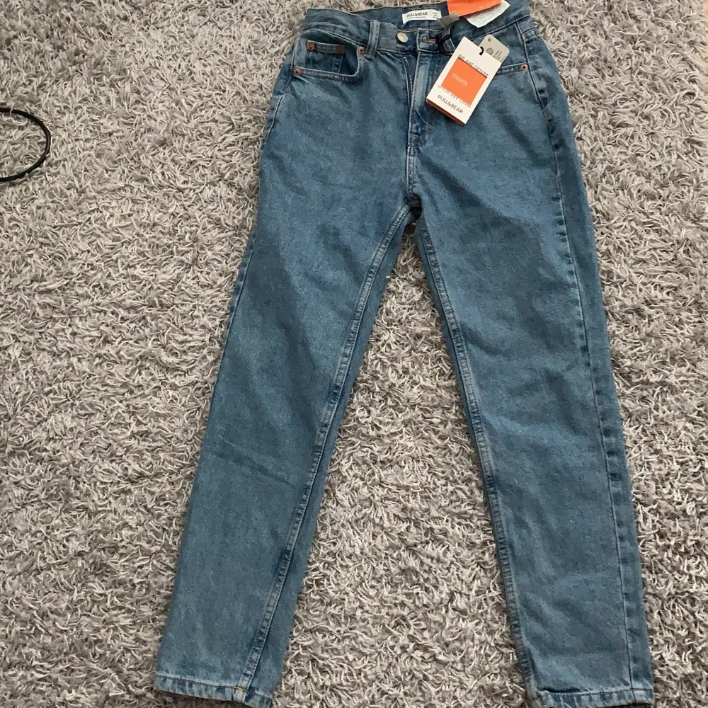 Säljer ett par super snygga mom jeans från Pull and bear! De har tyvärr inte kommit till användning sen jag köpte de och nu är det försent att skicka tillbaka! Storlek 32 och aldrig använda! Tar emot Swish och köparen står för frakt!😊. Jeans & Byxor.