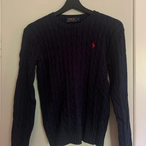 Marinblå kabelstickad tröja från Ralph Lauren. - En marinblå kabelstickad tröja från Ralph Lauren. Fint skick. Säljes pga att den aldrig kommer till användning. Storlek S. Nypris 1 295kr. Frakt tillkommer💋