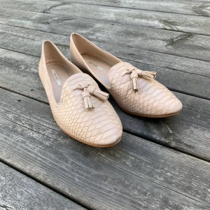 Zara kroko-loafers strlk 39 - Ett par beiga loafers i kroko-imitation från Zara. Använda endast ett fåtal gånger. Bra begagnad kvalitet. Frakt 55kr tillkommer. 
