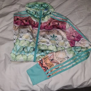 ADIDAS BUTTERFLY firebird tracktop - Oanvänd  adidas tröja  med fjärilsmönster, storlek 38. 