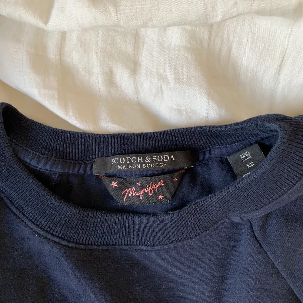 Marinblå sweatshirt ifrån scotch and soda med guldiga ränder vid ärmarna, ryggen på tröjan är i ett mer t-shirt material. I storleken XS💙  köparen står för frakten. Tröjor & Koftor.