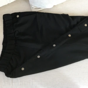 Byxor Monki fynd! - Byxor från Monki med knappar i sidorna, går att knäppa upp till knäna. Trasiga i sömmarna, går att lagas av den händiga. fyndpris! Hund förekommer i hemmet.