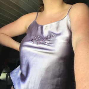 Lila silkes linne - Lila linne i silkesmaterial med blommor på bröstet💕                Frakt tillkommer på 35kr!!