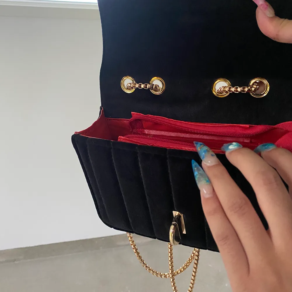 En Moschino handväska i velour-tyg med guldkedja som går att justera efter hur man vill bära upp väskan. Väskan är stabil och har en röd insida av fuskläder och en inreficka. Fraktar för extra kostnad 🦋 (OBS, ej äkta). Väskor.