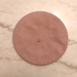 Ljusrosa basker - Supersöt ljusrosa/gammalrosa basker i 100% ull, helt i tiden just nu! Ull isolerar värme så du håller dig varm under de kalla årstiderna. Knappt använd, i mycket gott skick. Hämtas i Aspudden eller kan mötas upp i Stockholmsområdet!