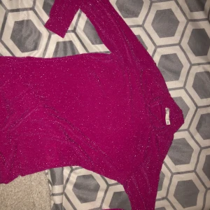 Festtopp strl XS - En rosa glittrig festtop från Nelly.com, aldrig använd och är i  nyskick. Storlek XS med tight passform
