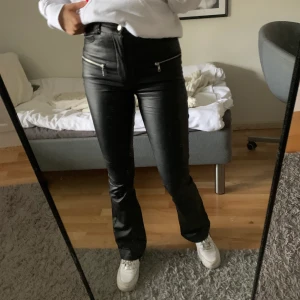 Svarta skinnbyxor - Svarta glansiga skinnbyxor från AFJ x NA-KD. Riktigt snygga men de kommer inte till användning längre. Långa i benen och sitter bra. Nypris på runt 600kr men de är helt slutsålda. Priset är inklusive frakten!