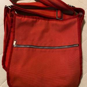 En röd Marimekko väska som kostar 200kr. Köparen står för frakten. 