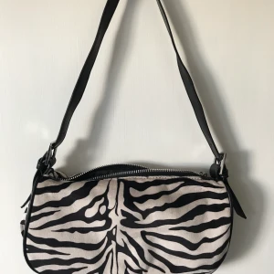 Väska zebra  - zebramönstrad baguetteväska med lite pälsliknande material, supersnygg till alla outfits! 