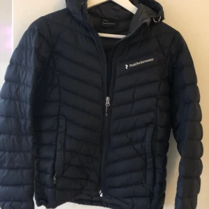 Dunjacka - Peak Performance  - Stilren jacka som kan användas i alla årstider. Fint skick.