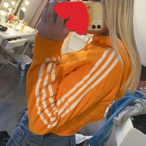 Adidas hoodie  - Säljer denna hoodie då den inte kommer till användning. Är från adidas och i färgen orange. Har själv klippt av den mudd som brukar vara där nere därav priset. Fint skick och är lika fin fast kortare🤩 storlek 34/XS pris 70kr (köparen står för frakt) 🤪 