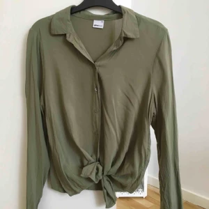  - Grön skjorta med knytning nertill från Gina Tricot. Endast använd 2-3 gånger! Storlek XS mycket bra skick!