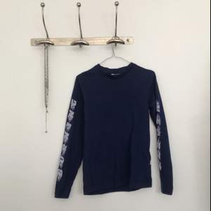 Mörkblå långärmad tröja med text på ärmarna från WEZC, använd fåtal gånger, riktigt fint skick! Köptes för ca 500kr