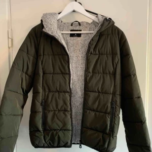  - Grön jacka med luva.