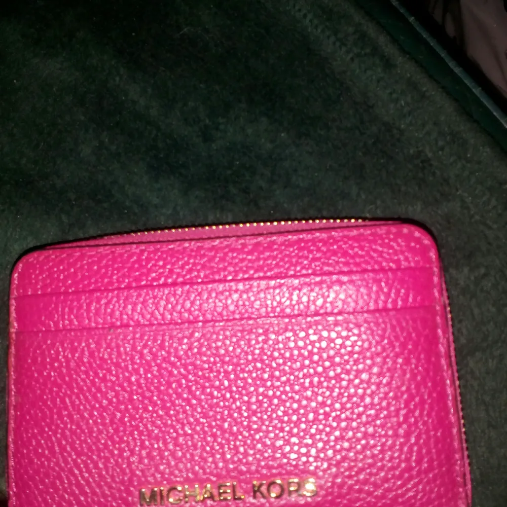 Liten plånbok fr MK, den är hallon röd o inte cerise som det ser ut som på bilden, den är naturligtvis äkta o aldrig använd😊Kan skickas mot fraktkostnad 😊. Accessoarer.