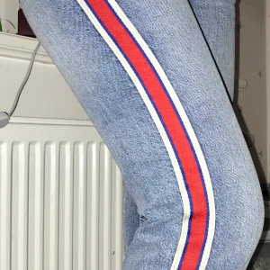 Blå jeans med röd och blå detalj - Blåa jeans med röd och blå detalj på båda långsidor på utsidan utav benen. Använd Max 5 gånger, säljs pga för små för mig. Köpta på Zara för 350kr nypris säljer för 250. Frakt ingår!!