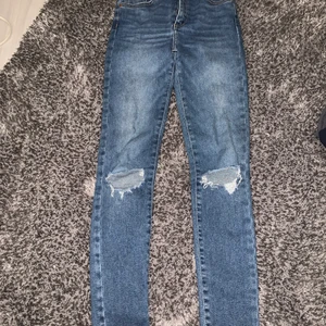 Jeans - Ett år fina jeans med hål på knäna. De är tighta men bra stretch 