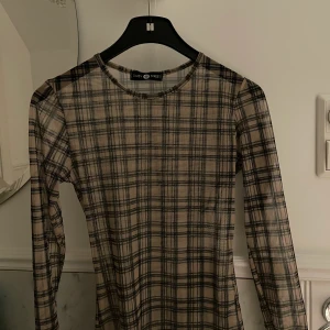 Rutig trendig tröja säljes  - Tröjan är i storlek xs men skulle själv säga xs-s! Använd mycket fåtal ggr då den är ganska ny! Tröjan är lite genomskinlig men som man ser på bilden, inte så mycket!
