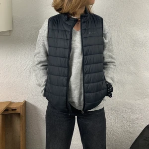 Everest väst - Säljer en svart Everest väst i storlek 146/152. Bra skick, säljer då den inte passar mig längre. Min syster på bilden är en xs/s och den passar henne men är i minsta laget. Perfekt till våren  med en stickad tröja under. 💗💗                                         100kr + frakt