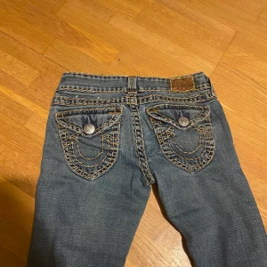 True religon  - Ett par skit snygga jeans från true religon, lågmidjade och bootcut. Fina fickor och fina detaljer på jeansen, säljer dom då dom är för små för mig.  Buda från 250! 