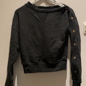 Sweatshirt med knappar från H&M - Sweatshirt med knappar från H&M som aldrig är använd. I storlek 34. I superfint skick!!
