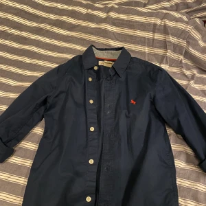 Marinblå skjorta  - Marinblå skjorta i bra skick. Storlek 8-9år, Använd fåtal gånger. Pris kan alltod diskuteras💗