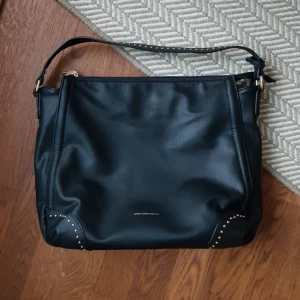  - Svart väska från United Colors of Beneton. I mkt bra skick.  Frakt betalas av köparen eller så kan vi träffas vid centralen eller täby 