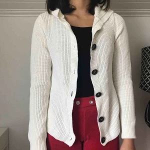  - En vit stickad kofta från JC som har knappar och en luva. Kostar 120kr inklusive frakt.