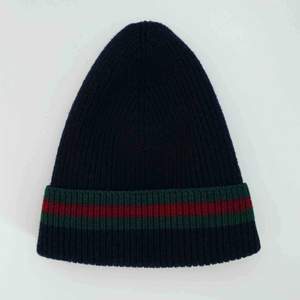 Authentic Gucci toque/hat. Signature red and green web detailing on black. Made of wool (70%) & Silk (30%).  Storlek: S 