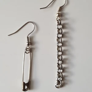  - Örhängen i metall med kedja och säkerhetsnål. Kan skickas om köparen står för fraktkostnaden. 