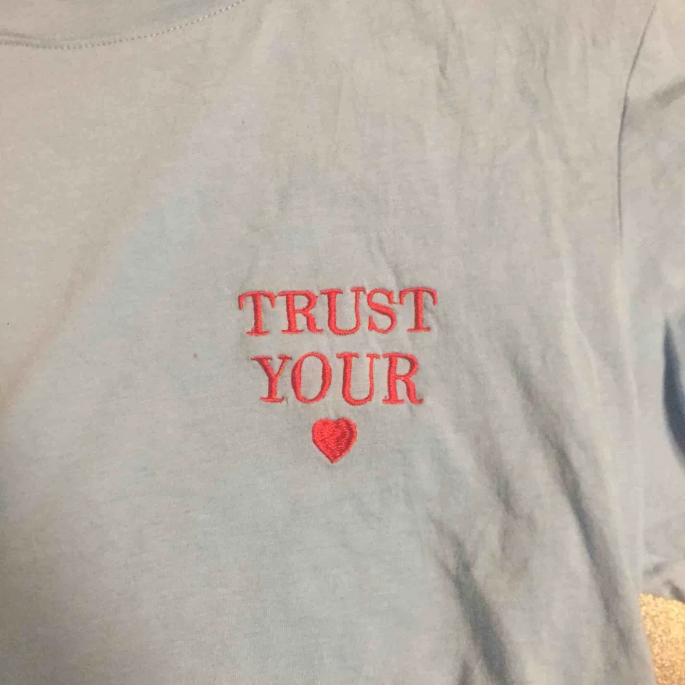 Blå T-shirt med texten ”trust your ❤️” i rött, köpt på monki för ett tag sen. T-shirts.