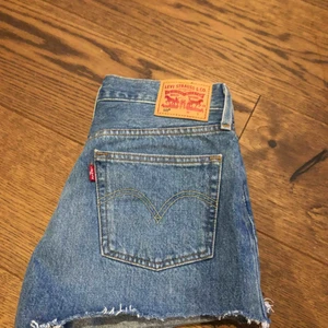  - Oanvända Levis shorts.  Blåa shorts med knappar som stängning vid gylfen. Köparen tar hand om frakt. 