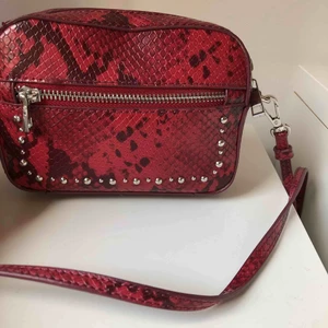  - Röd ”sneak” väska från zara med silvermedaljer. Liten och praktisk, perfekt när man bara vill ha med sig lite saker. Justerbart band, rymlig för sin storlek