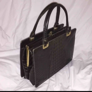  - En jätteeesnyyygg vintage handväska i typ lackat”krokodilskinn” (fake) med gulddetaljer! Super snygg och retro.