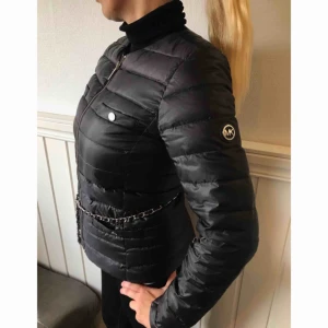  - Svart Michael kors dunjacka i storlek S. Väldigt bra skick. Kedjan är avtagbar.   Ska jackan fraktas tillkommer en kostnad på 100kr. Kan vi mötas i Kungsbacka/Kållered blir frakten gratis.