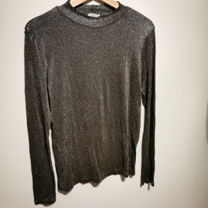  - FILIPPA K halvpolo i tunnt Glitter material som formar sig. 