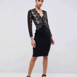  - OANVÄND svart klänning med spets från Nelly. Prislapp kvar. Nytt pris 599kr. Köparen står för frakten 