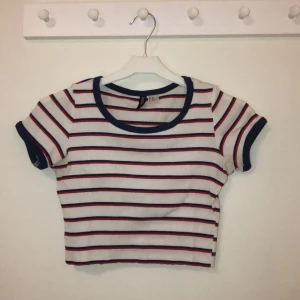 Cropped T-shirt  - Kort T-shirt från H&M, avklippt själv! Bra skick, blå vit och röd. Säljer för 40kr, du står för frakten🥰