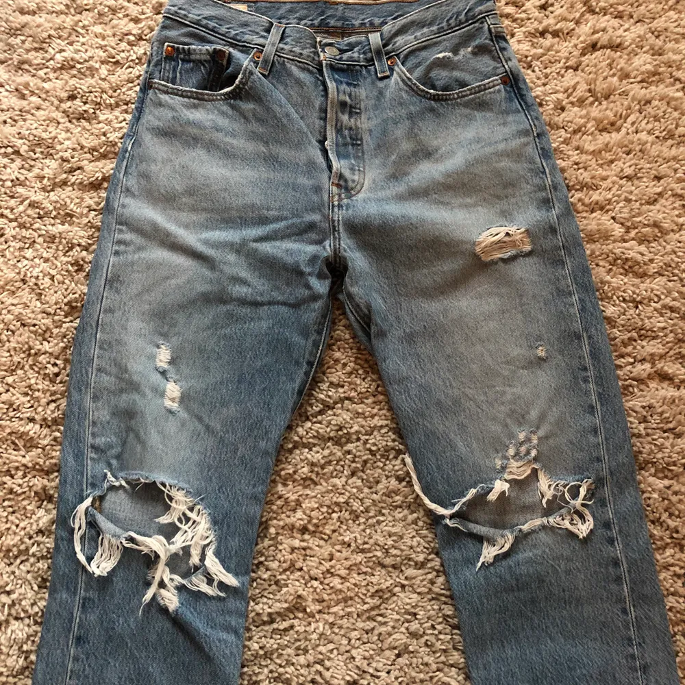Klassiska 501 Levis jeans med slitningar. Jättesnygga men har tyvärr blivit för små för mig. Bra skick, fler bilder på passform kan skickas vid förfrågan.. Jeans & Byxor.