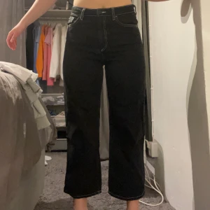Svarta croppade jeans - Jeans från monki som inte säljs längre. Svarta jeans i en tvättad modell med vita sömmar. Använda få gånger och jättebra skick. Köparen står för frakten. Storlek 28 i midjan.