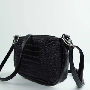 Galaxy✨ by M.E.J UF - Liten väska med en kort och en lång axelrem. Väskan är glittrig och har silvriga detaljer. 