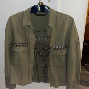 Grön jacka - Cool militärgrön skjortjacka med tofsdetaljer på ryggen. Storlek S