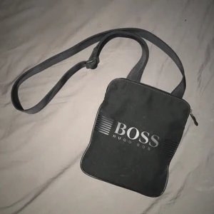 Hugo boss axelväska  - Hugo boss axelväska i den skönaste färgen black on black, väldigt fräsch och inga fel!