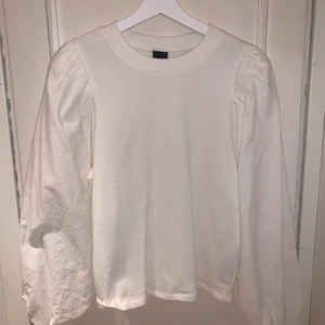 Topp från Gina Tricot - Fin topp från Gina Tricot som använts ett fåtal gånger. Ärmarna är i ett typ skjortmaterial medan resten av tröjan i vanligt tyg. Storlek M