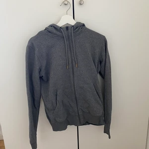 Grå hoodie med dragkedja  - Grå hoodie med en dragkedja, storlek 38, bra kvalitet och har bara används några gånger. Säljer till första som skriver. ( skriv om ni vill ha fler bilder). (50kr + frakt) 