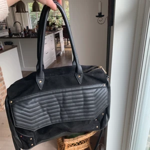 Svart snygg väska - Säljer denna sjukt snygga pimkieväskan, den har fickor som man kan ha smågrejer i på insidan och ett långt band om man hellre vill ha den runt sig 💕💕 Frakt tillkommer.