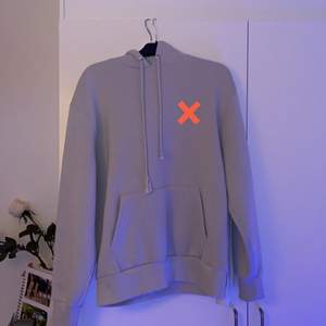 Grå hoodie med neonrosa/orangea detaljer på bröstet och ärmarna. Köpt för ca 1 år sedan och används Max 10 gånger. Den är väldigt stor för storleken, enligt mig är den mer lik M eller L. Köptes för 300kr från Zalando 
