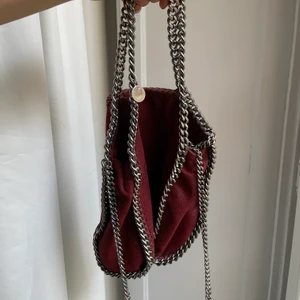 Väska Stella McCartney  - Intressekoll!! Vill se om någon är intresserad av min vinröda Stella McCartney falabella. Jag köpte den för ca 4år och i vädligt fint skick utåt! Väskan har ett hål i innefodret och några sömmar som släppt ( se bilder). Dessvärre inga kvitton eller likande kvar. Köpt för ca 7000kr. Buda från 3000! Råkade dra igång en budgivning som nu står att den är avslutad. Men väskan finns kvar!
