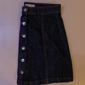 Mörkblå jeanskjol  - Mörkblå jeanskjol med knappar på framsidan. Aldrig använd då den inte passar. Bara att skriva vid intresse, frågor eller önskan om fler bilder. Endast post och Swish.