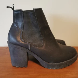 Svarta stövletter med klack  - Svarta stövletter med klack från märket Vox. Storlek 39.